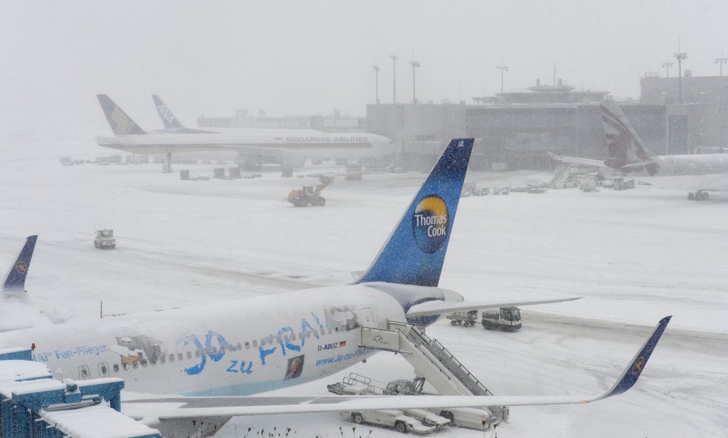 epa03620253 Passenger jets are parked at the gates at the snow-covered Frankfurt Airport in Frankfurt Main, Germany, 12 March 2013. Heavy snow forced the airport to close temporarily.  EPA/Arne Dedert