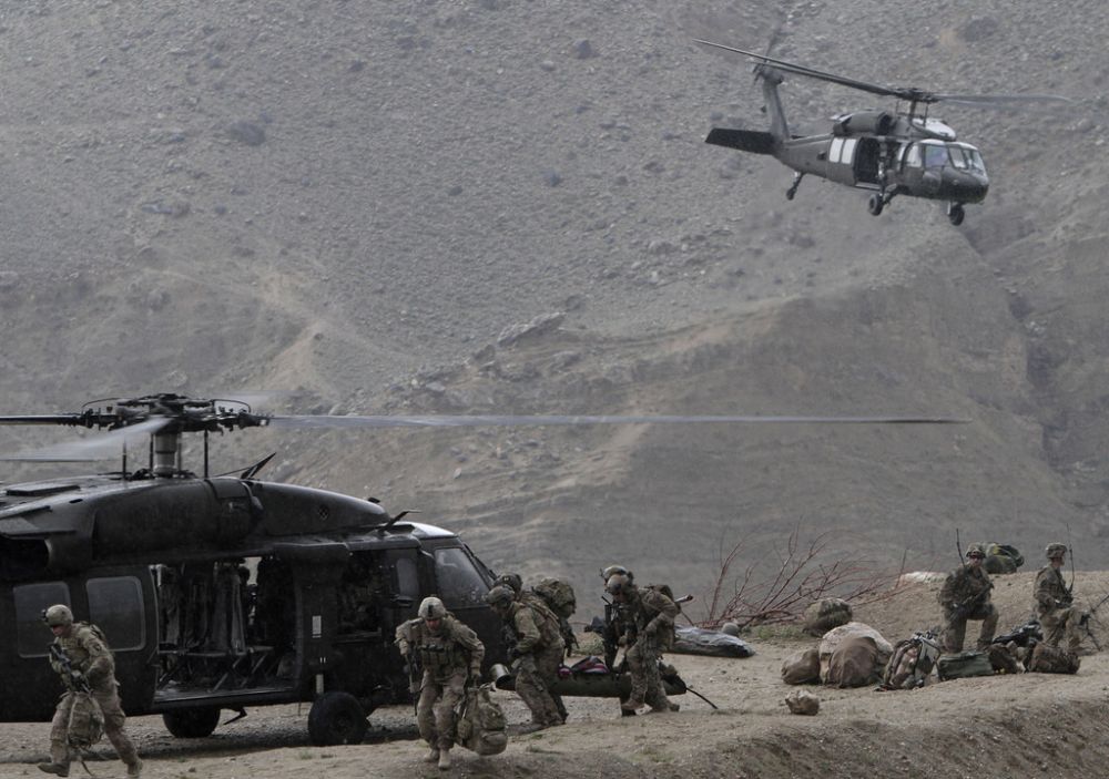 U.S. Black Hawk helicopters arrive to the scene after a NATO helicopter crashed in a field killing two American service members, near Gerakhel, eastern Afghanistan, Tuesday, April 9, 2013. The U.S.-led International Security Assistance Force said the cause of the crash is under investigation but initial reporting indicates there was no enemy activity in the area at the time. It did not immediately identify the nationalities of those killed. But a senior U.S. official confirmed they were Americans.  (AP Photo/Rahmat Gul)