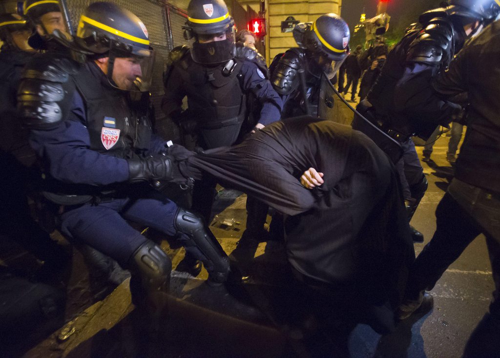 A traditional priest is taken away during clashes with riot police on the sideline of a rally to protest against French President Francois Hollande's social reform on gay marriage and adoption at the Invalide square in Paris, Friday, April 19, 2013. France's upper house of parliament, the Senate, adopted last Friday the law that would allow same-sex marriage and grant gay couples the right to adopt children. Returned to the National Assembly for a second reading, the bill's final vote is scheduled for April 23. (AP Photo/Michel Euler)