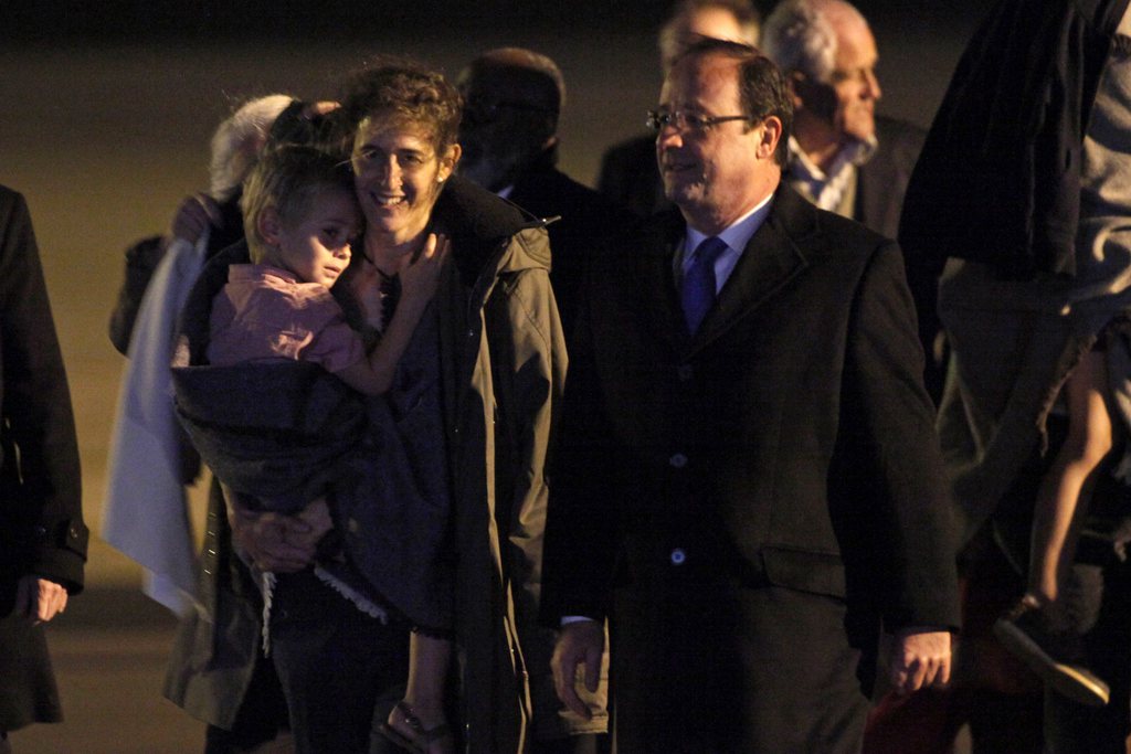 French hostage Albane Moulin-Fournier, left, is welcomed by French President Francois Hollande, right, as she arrives from Yaounde, at the Orly airport, near Paris, Friday, April 20, 2013. A French family with four young children kidnapped at gunpoint by Islamic extremists in northern Cameroon was freed after two months in captivity, returning Friday to safety in the Cameroonian capital. (AP Photo/Thibault Camus)