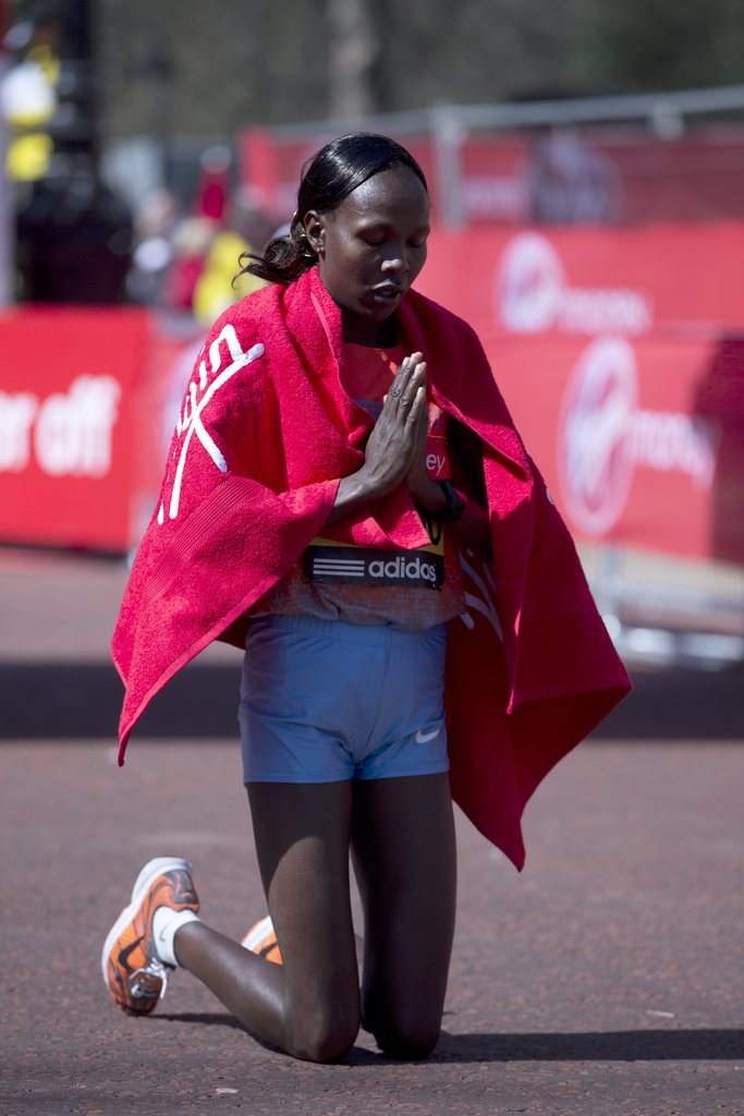 Priscah Jeptoo prays after she won the women's London Marathon in the Mall, in London, Sunday, April  21, 2013. A defiant, festive mood prevailed Sunday as the London Marathon began on a glorious spring day despite concerns raised by the bomb attacks on the Boston Marathon six days ago. Thousands of runners offered tributes to those killed and injured in Boston. The race began after a moment of silence for the victims in Boston, and many here wore black armbands as a sign of solidarity.(AP Photo/Alastair Grant)