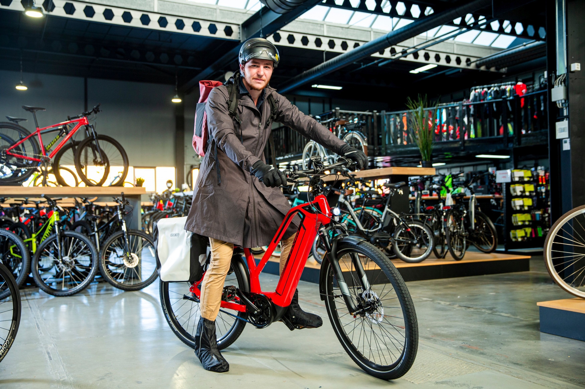 Léo, chez Ciclissimo à Gland, essaye des vêtements d'hiver adaptés à ses déplacements en ville.