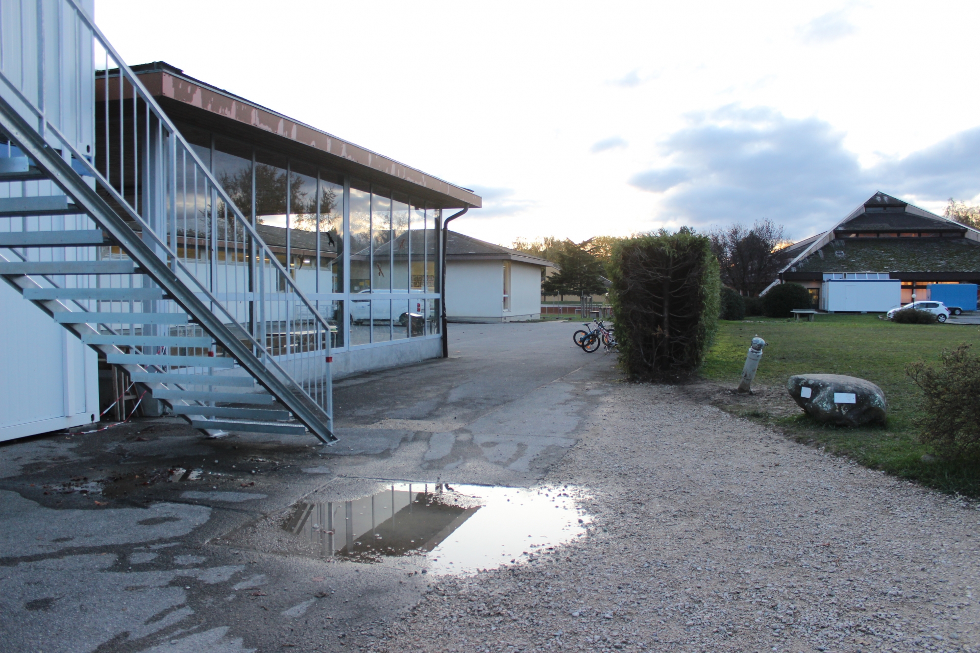 L'école, à gauche, construite provisoirement il y a une cinquantaine d'années ne répond plus ni aux normes, ni aux besoins. Au fond, la salle polyvalente.