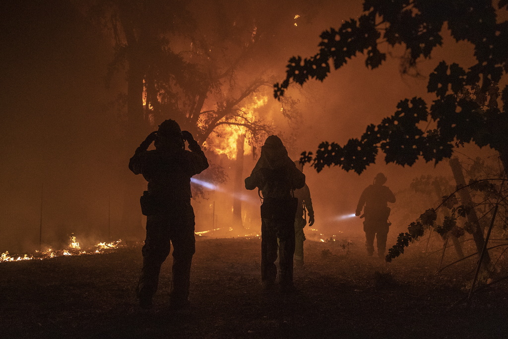 Un pompier évalue un immeuble en feu alors que l'incendie de Kincade continue de faire rage à Healdsburg, en Californie.