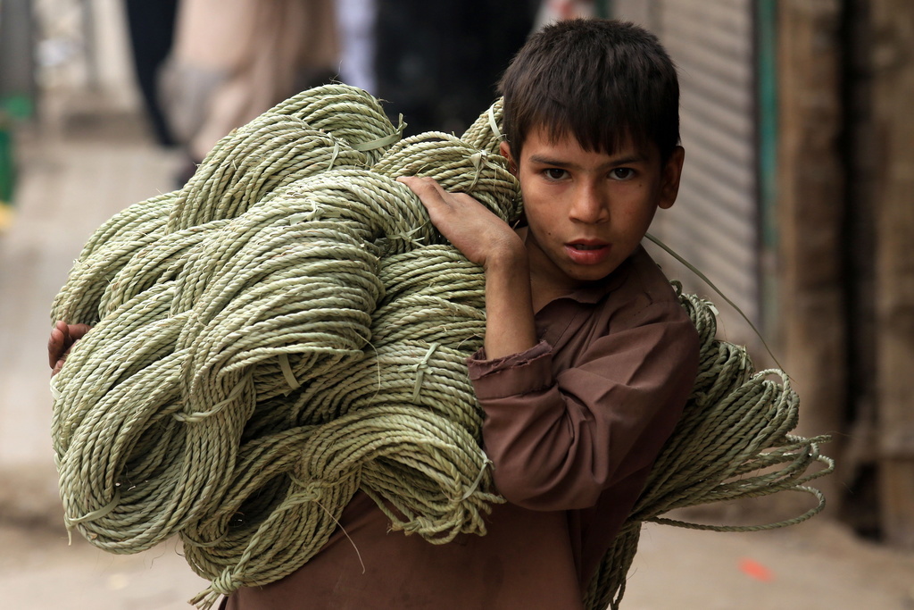 Un enfant sur cinq se trouve en situation de pauvreté et plus de 250 millions sont déscolarisés, comme ce petit Pakistanais qui va vendre des cordes au bord d'une route.