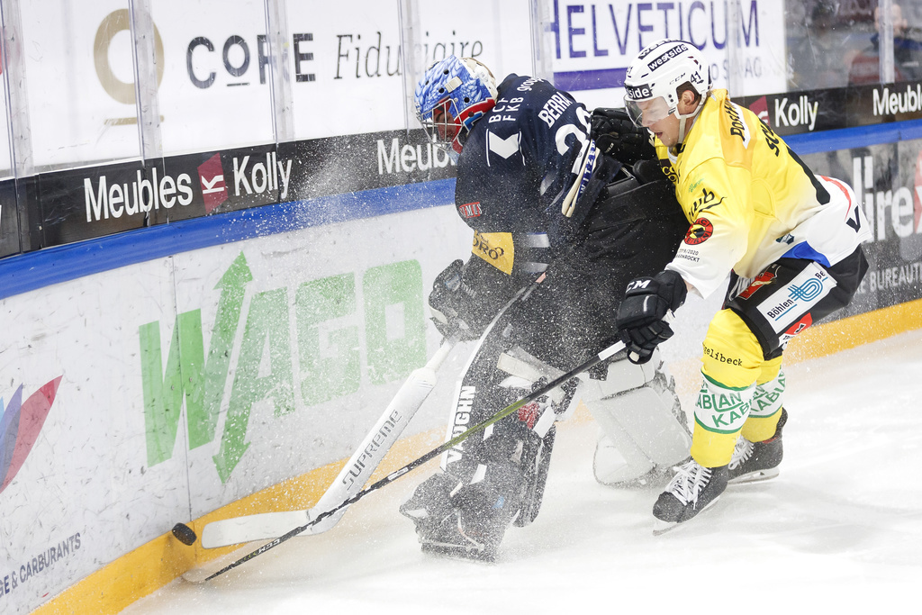 Le gardien fribourgeois Reto Berra lutte pour le puck avec l'attaquant bernois Gregory Sciaroni.