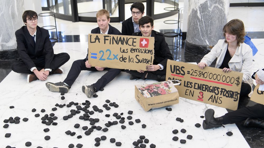 Mardi à Lausanne, le Morgien Hamza Palma (à g.) et des membres de la Grève du climat et d'Extinction Rebellion ont investi le hall de l'UBS de la place Saint-François.