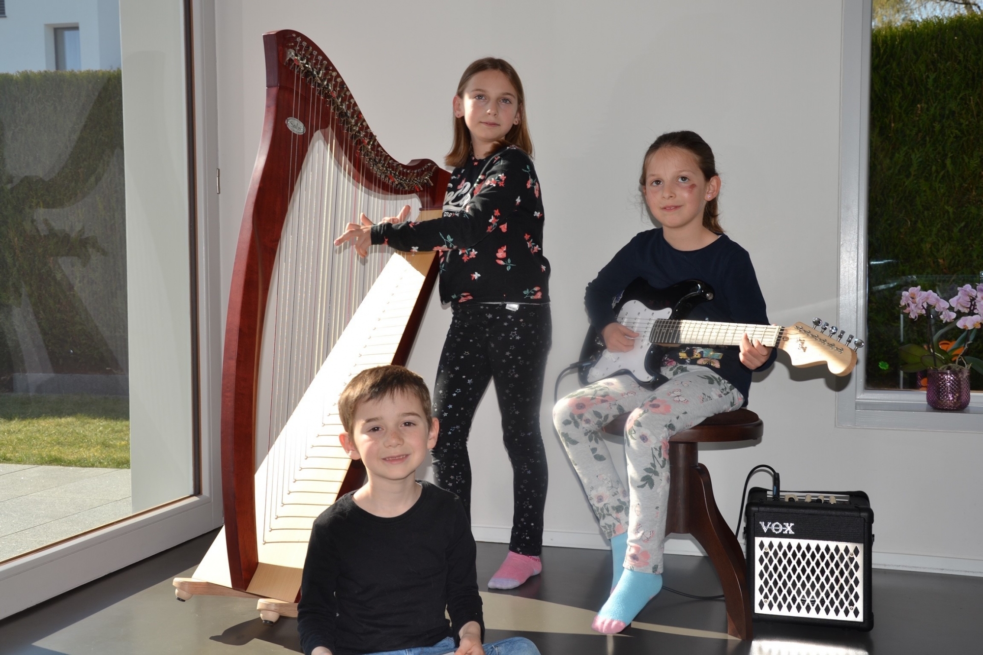 Lilla et sa harpe, Aude à la guitare électrique et Matyas qui s'initie au solfège avant de commencer des cours de batterie.