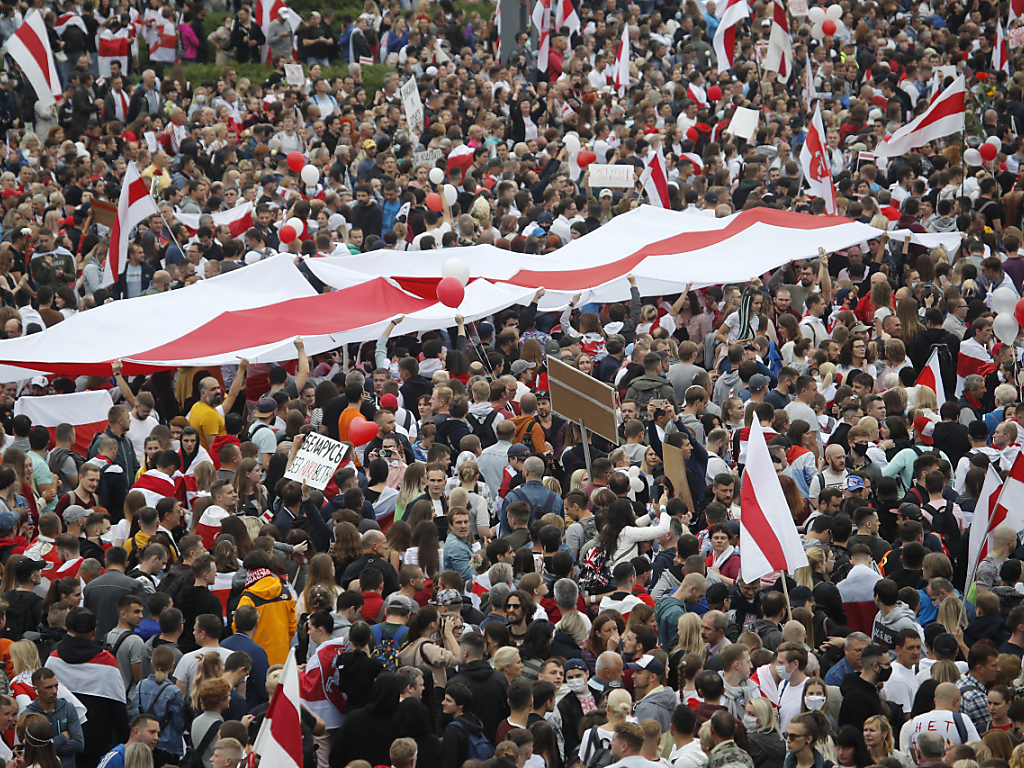 Brandissant des drapeaux blanc et rouge, les couleurs de la contestation, des dizaines de milliers se sont réunis sur la place de l'Indépendance à Minsk.