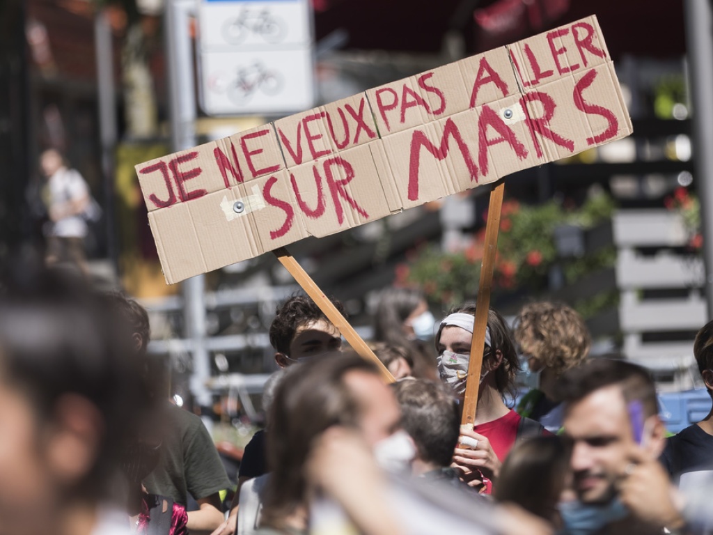 Sur les banderoles et pancartes, on pouvait lire des slogans tels: "Je ne veux pas aller sur Mars", "Croissance infinie dans un monde fini", "Penser le changement pas changer le pansement" ou encore "Elu-e-s Bougez-vous le Q...i!".